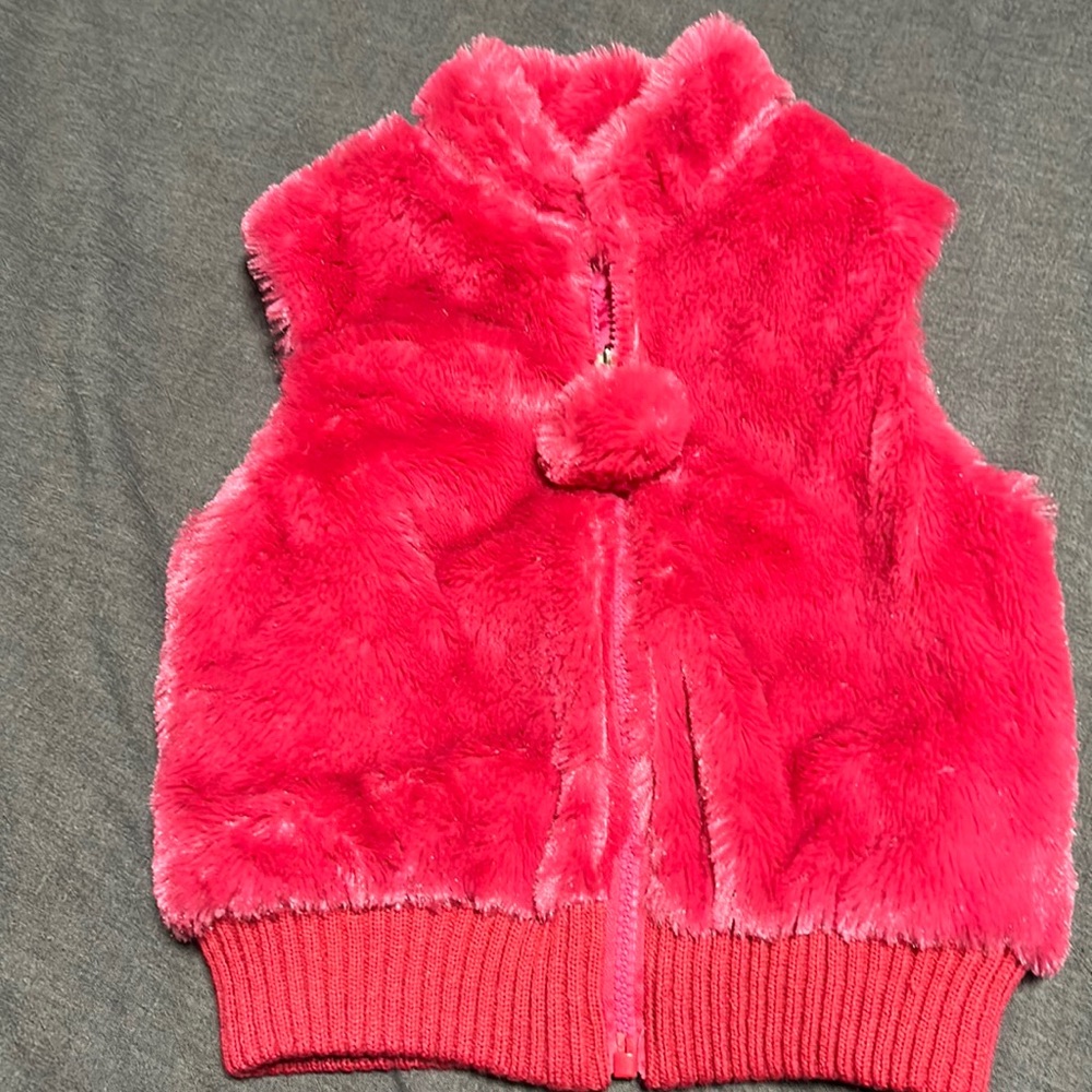 Toby vest with pom-pom on zipper.  New without tags.